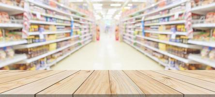 Wood table top with supermarket grocery store aisle interior blurred background with bokeh light for product display photo