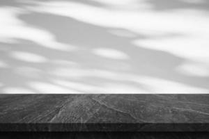 Marble table top with tree shadow drop on white wall background for mockup product display photo