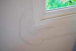 house wall near the window with some water stain show peeling paint photo