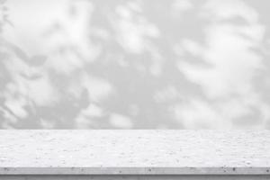 Marble table with tree shadow drop on white wall background for mockup product display photo