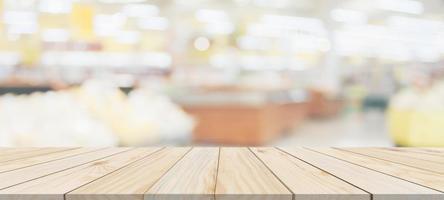 Wood table top with supermarket grocery store blurred background with bokeh light for product display photo