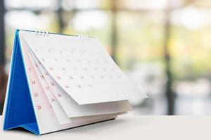 desk calendar on table with blurred bokeh background appointment and business meeting concept photo