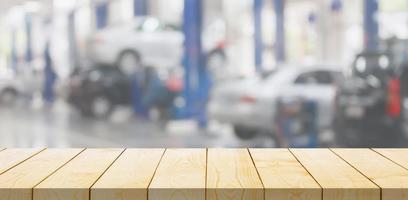 Empty wood table top with car service centre auto repair workshop blurred background photo