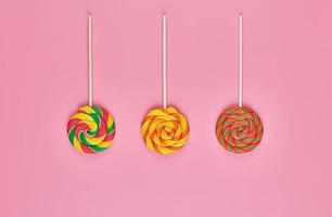 Sweet lollipops on pink background photo