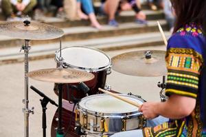 Drummer man playing drums percussion with drum sticks, drum set on concert stage, sticks and drums photo