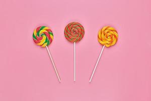 Sweet lollipops on pink background photo