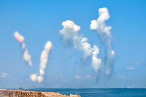 White carbon fiber clouds in blue sky hiding naval destroyers from anti-ship missiles, military show photo