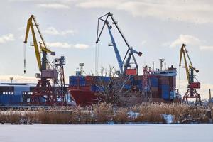 Moored ships and harbor cranes in port photo