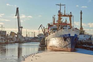 barcos amarrados y grúas portuarias en el puerto foto