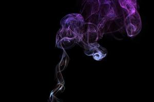 Multicolored smoke for aromatherapy relaxation on black background, beautiful swirled puffs of smoke photo