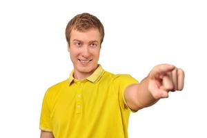 un hombre atractivo y sonriente con una camiseta amarilla casual apuntando hacia adelante, con un fondo blanco aislado foto