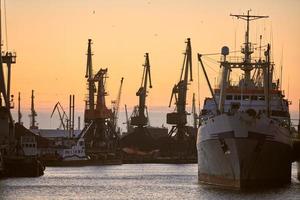 Ships in sea port on sunset background photo