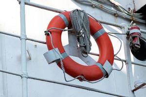 Lifebuoy on handrails of frigate or warship. Rope wound on handrails with lifesaver. photo