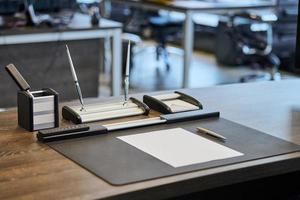 lugar de trabajo de oficina con papelería. jefe, jefe, supervisor o jefe del lugar de trabajo de la empresa en la oficina moderna. cómoda mesa de trabajo y silla de cuero para computadora. foto