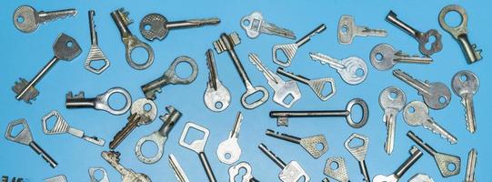 Keys set on blue background. Door lock keys and safes for property security and house protection. Different antique and new types of keys. photo