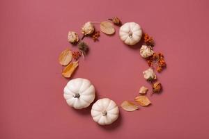 Autumn flat lay wreath of pumpkin, leaves and flowers with berries top view with copy space photo