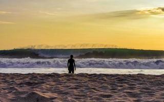 colorido atardecer dorado gran ola y playa puerto escondido mexico. foto