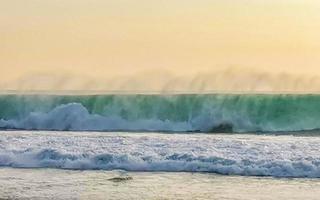 Colorful golden sunset big wave and beach Puerto Escondido Mexico. photo