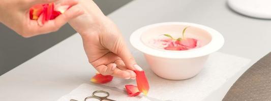 Manicurist decorates table with petals photo