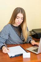 Business woman is writing on a document photo