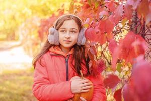 una adolescente con una chaqueta naranja con una calabaza en las manos. retrato otoñal de una niña. foto