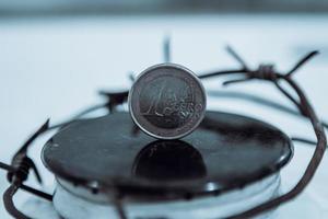 Restrictions causing shortages in gas supplies, burners Gas stove with barbed Wire and euro coin, concept gas crisis photo