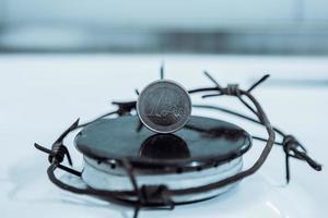 Restrictions causing shortages in gas supplies, burners Gas stove with barbed Wire and euro coin, concept gas crisis photo