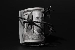 billete de dólar con alambre de púas, crisis económica, efecto de fondo con poco ruido foto