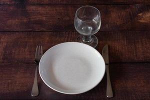 A place setting for one on a rustic brown table. photo