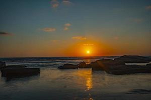 Beautiful view of the sea with the sun shining in a blue sky in the background photo