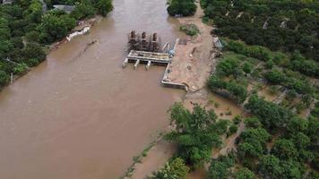 inonder la construction de la vanne, construction inachevée. la rive du fleuve s'est effondrée en raison de fortes pluies et d'un fort débit d'eau. video