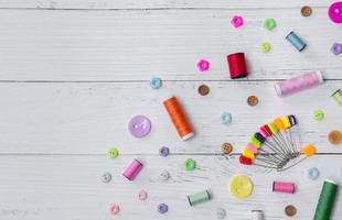 Sewing background. Accessories for needlework on old wooden background. photo