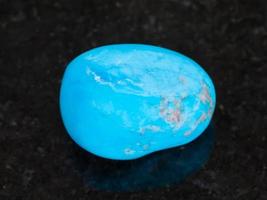 tumbled Turquenite blue howlite stone on dark photo