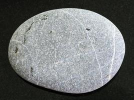 tumbled Graywacke sandstone on dark background photo
