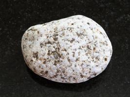 tumbled of white Granite stone on dark background photo