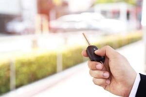 The salesman is opening and closing the car door with the key. For safety photo