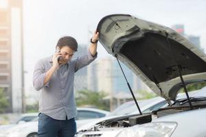 close up businessman hand using a mobile smart phone call a car mechanic ask for help assistance because car broken. photo