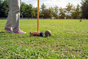 el jugador de pelota de madera está usando un bate de pelota de madera para golpear la pelota de madera en la portería. Woodball es un deporte que se juega similar al golf. enfoque suave y selectivo. foto