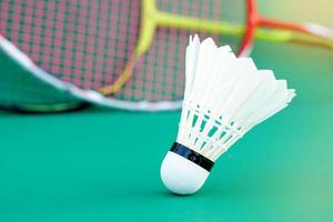 white shuttlecock on green background, blurred badminton racket background. soft and selective focus. photo