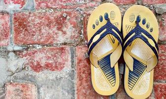 Old slippers on the red brick floor photo