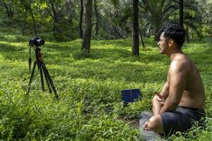 View of a man conducting virtual fitness class with group of people at home on a video conference. Fitness instructor taking online yoga classes photo