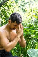 hombre visto de cerca, sin camisa haciendo estiramientos en colchoneta de yoga, ejercicio, américa latina foto