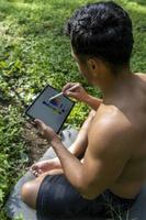 young man explaining drawing on his tablet, while teaching chakra, yoga and meditation class, mexico photo