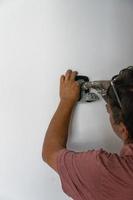 man installing password protected box that stores door access keys photo