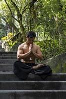 young man doing meditation on a stairway in a forest, mexico photo