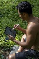 joven explicando el dibujo en su tableta, mientras enseña clases de chakra, yoga y meditación, méxico foto