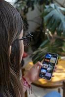 young hispanic woman, looking at her cell phone checking her social networks photo