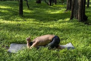 latin american man doing yoga posture, yoga posture, Bee backwards Prsthatah Brahmara, forest photo