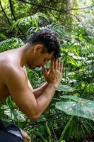 latin american man doing yoga posture, yoga posture, Bee backwards Prsthatah Brahmara, forest photo