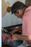 latino man looking for tools in his toolbox, hispanic, with screwdriver in hand photo